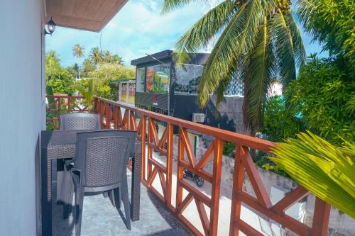 a balcony with a table and chairs on a fence at The Zen Den in Thulusdhoo