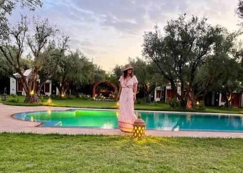 a woman standing in front of a swimming pool at GreenLife Marrakech in Marrakech