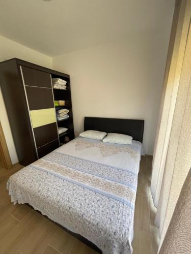 a bedroom with a bed with a black headboard at Orlovs Family in Dobra Voda