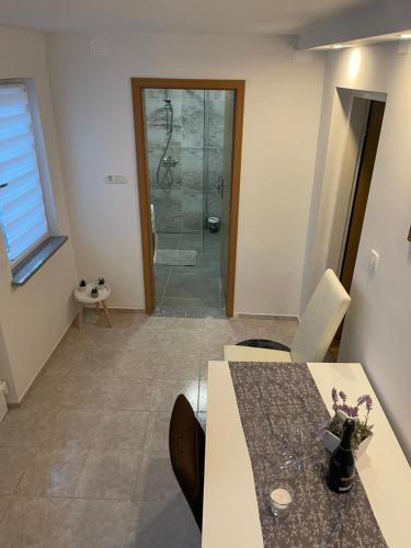 a bathroom with a shower with a table and a table and chairs at Apartma Lavanda in Koper