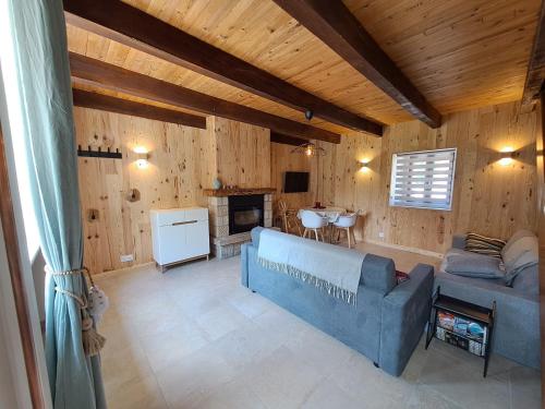 a living room with a couch and a fireplace at Gîtes Le Lilas - Lac de Pareloup in Canet-de-Salars