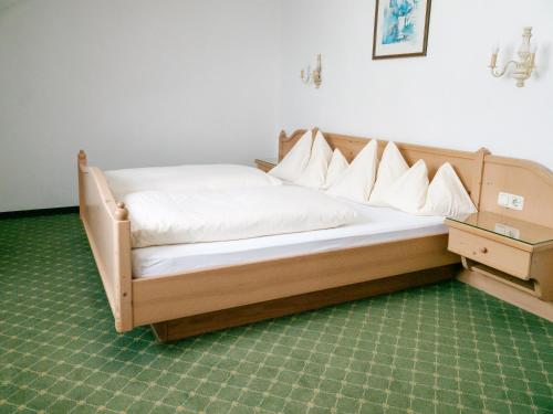 a bed with white sheets and a wooden headboard at Ferienwohnung im Naturpark Almenland in Fladnitz an der Teichalm