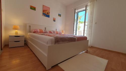 a bedroom with a large bed and a window at Apartman Filis in Hvar
