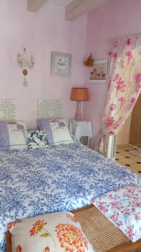 une chambre avec un lit avec une couette bleue et blanche dans l'établissement LES BRUYERES chambre d'hôte de charme Calme assuré, à Loupia