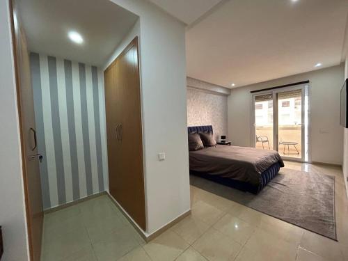 - une chambre avec un lit et une porte donnant sur un balcon dans l'établissement Islane vue piscine, à Agadir