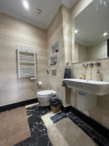 uma casa de banho com um lavatório, um WC e um espelho. em Marrakech M Avenue CR 7 appart terrasse em Marrakech