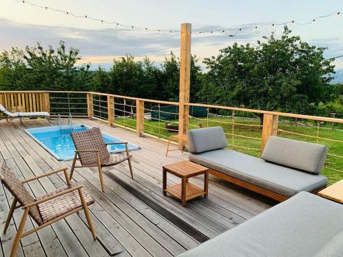 a deck with a couch and chairs and a pool at Grant's in Labin