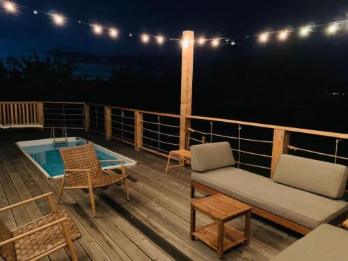 a deck with furniture and a swimming pool at night at Grant's in Labin