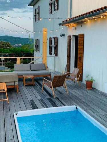 a deck with a pool and a couch and chairs at Grant's in Labin