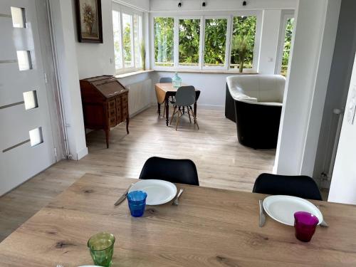 d'une salle à manger avec une table, des chaises et une baignoire. dans l'établissement Appartement moderne Proche mer, Le Pouldu, à Clohars-Carnoët