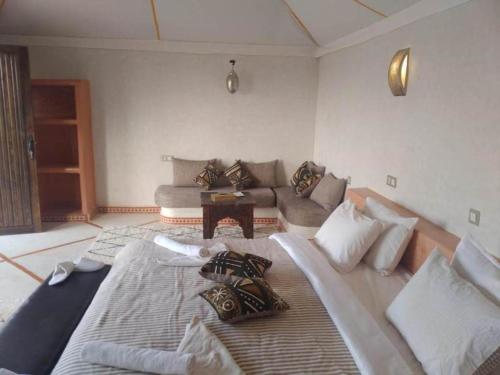 a living room with a large bed and a couch at Desert Luxury Camp in Mhamid