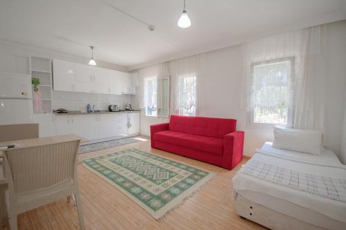 een woonkamer met een rode bank en een keuken bij Kaya Apart Datca in Datca