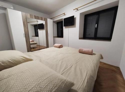 a bedroom with two beds and a mirror at Aretha apartman i sobe in Novi Vinodolski