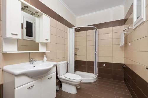 a bathroom with a toilet and a sink and a shower at Ionian Blue in Perama