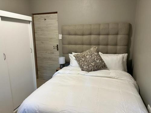 a bedroom with a large white bed with a pillow at St Ives beach access apartment in Margate