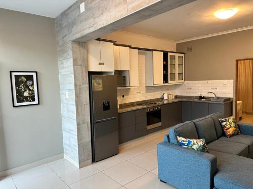 ein Wohnzimmer mit einem Sofa und einer Küche in der Unterkunft St Ives beach access apartment in Margate