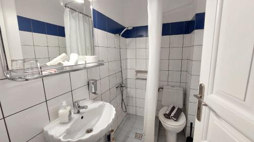 a white bathroom with a sink and a toilet at Olympic Villas in Oia