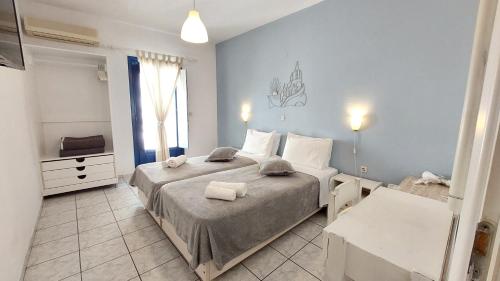a bedroom with two beds and a television in it at Olympic Villas in Oia