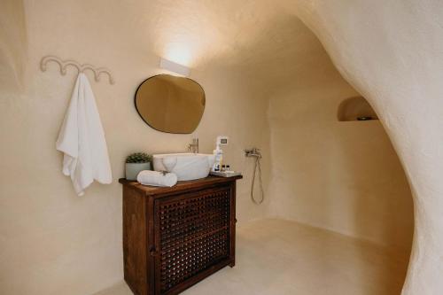 La salle de bains est pourvue d'un lavabo et d'un miroir. dans l'établissement Villa Patitiri cave house with private pool in Megalochori Santorini, à Megalochori