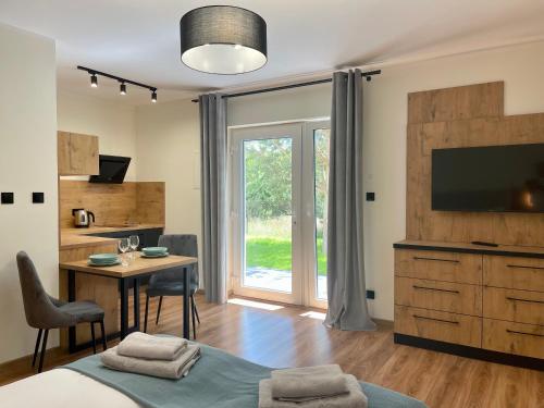 a bedroom with a bed and a table and a television at Apartamenty MarSyl in Jastrzębia Góra