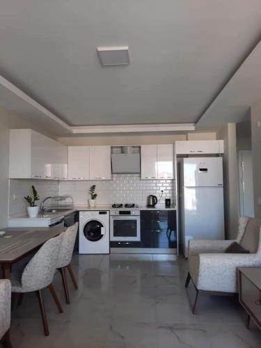 a kitchen with white appliances and a table and chairs at Alanya-Avsallar 55m 1+1 in Avsallar