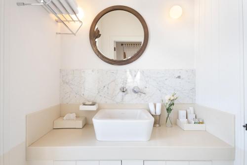 a white bathroom with a tub and a mirror at Nars Ilica Hotel Beach Adults Only 12Plus in Cesme