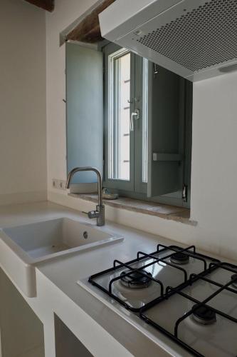 a kitchen with a sink and a stove top oven at Casa Caminate CnC bed&kitchen in Fano