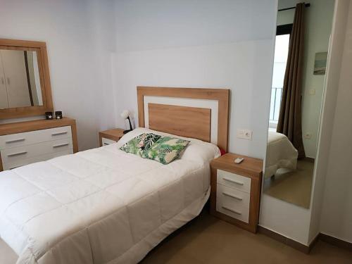 1 dormitorio con cama, tocador y espejo en Loving Corazones, en Granada