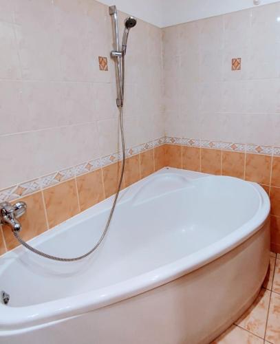 a bath tub with a shower in a bathroom at Perfect flat city centre in Sigulda