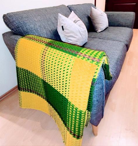 a blanket on the back of a couch at Perfect flat city centre in Sigulda