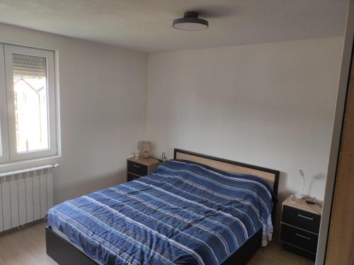una camera da letto con un letto con un piumone blu e una finestra di Cozy apartment with mountain view 