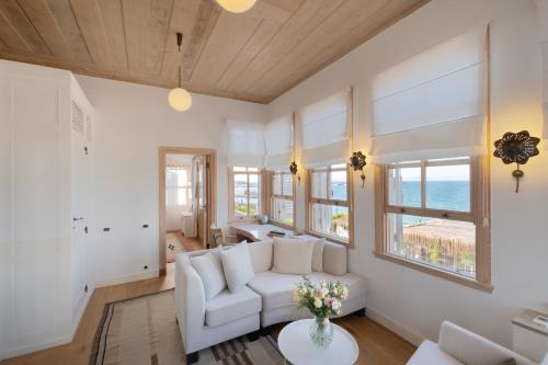 a living room with white furniture and a view of the ocean at Nars Ilica Hotel Beach Adults Only 12Plus in Cesme