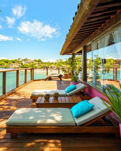 a deck with chaise lounges and tables on a house at Insólito Boutique Hotel & Spa in Búzios