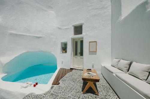 a room with a couch and a table at Villa Patitiri cave house with private pool in Megalochori Santorini in Megalokhori