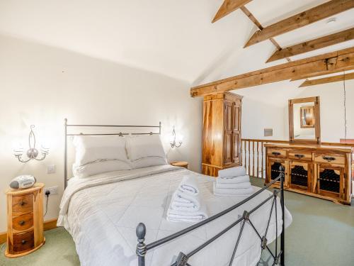 a bedroom with a large bed with white sheets at The Granary - Uk44520 in North Thoresby