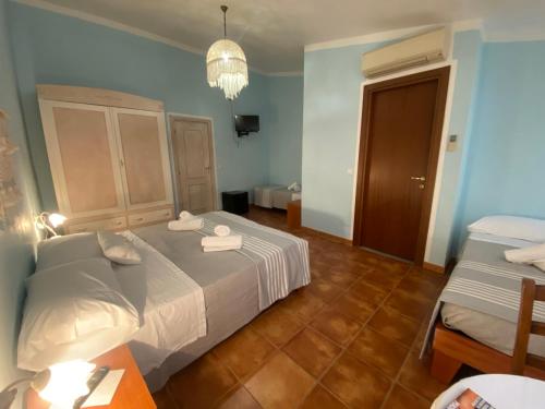 a bedroom with two beds and a chandelier at B&B La Pitraia in Sant Antonio Di Gallura