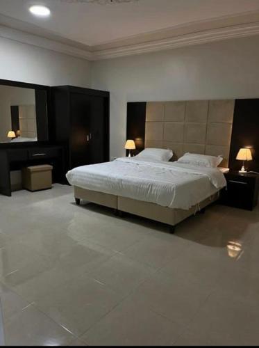 a bedroom with a large bed and a mirror at شقق بدور أرضي in Al-Salam