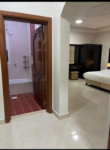 a room with a bathroom with a shower and a bed at شقق بدور أرضي in Al-Salam