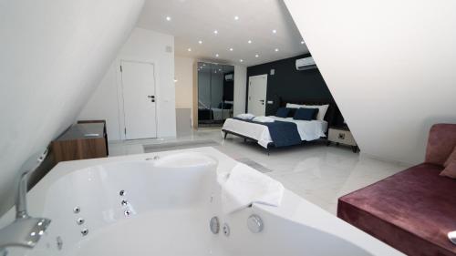 a bathroom with a tub and a bed in a room at VİLLA ADA in Kaş