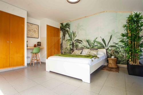 een slaapkamer met een bed met planten aan de muur bij Duplex LUX Jota Jota in Lloret de Mar