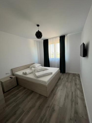 a white bedroom with a bed and a window at Casa Lucia in Sibiu