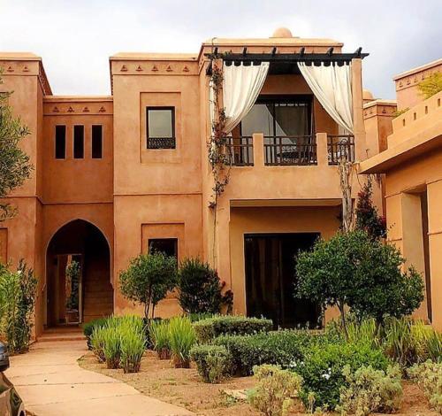 a large building with a balcony and a porch at Appartement avec vue sur l'Atlas et piscine in Marrakech