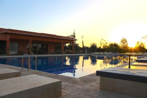 a swimming pool in front of a building at Appartement avec vue sur l'Atlas et piscine in Marrakesh