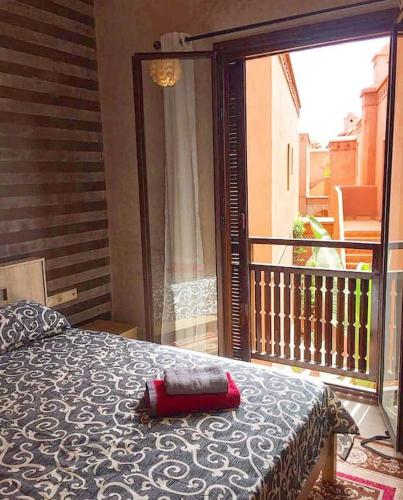 a bedroom with a bed and a balcony at Appartement avec vue sur l'Atlas et piscine in Marrakech