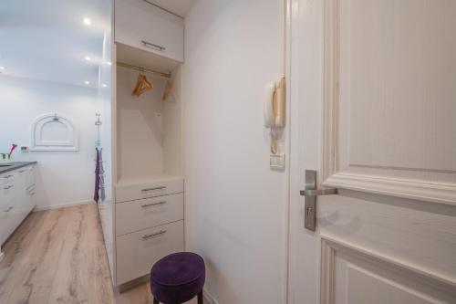 eine weiße Küche mit einem lila Stuhl neben einer Tür in der Unterkunft Résidence Le Cristal - Nant Blanc 2 - Happy Rentals in Chamonix-Mont-Blanc