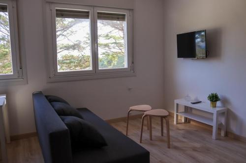 a living room with a couch and two windows at Casal Do Crego in O Grove