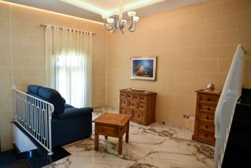 a living room with a blue chair and a crib at Azure W B&B in San Lawrenz