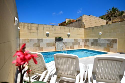 a group of chairs and a swimming pool at Azure W B&B in San Lawrenz