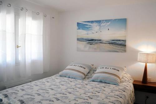 a bedroom with a bed with two pillows on it at Superbe, rénové, au calme, plage 200m, terrasse vue Mer! in Rayol-Canadel-sur-Mer