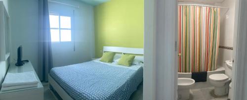 a bedroom with a bed and a bathroom with a shower at Hostal Baobab in El Puerto de Santa María